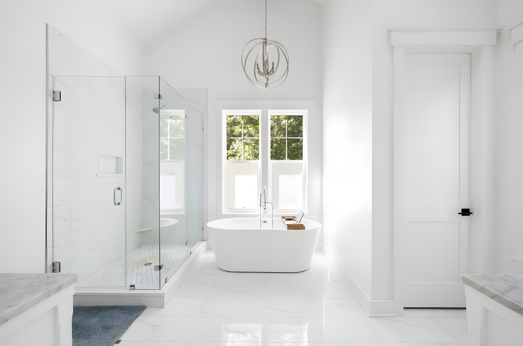 Primary bath with freestanding tub, marble shower, and chandelier